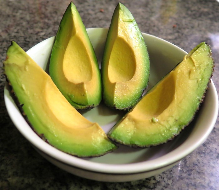 An avocado, sliced into four quarters
